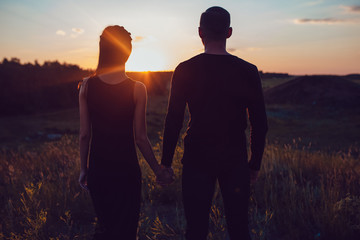 Love story . Couple at sunset. On the background of the sky. Clouds.