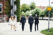 © Astrakan Images - Rear view of male and female graduates walking on footpath at campus