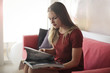 © olly - Young woman reading a magazine