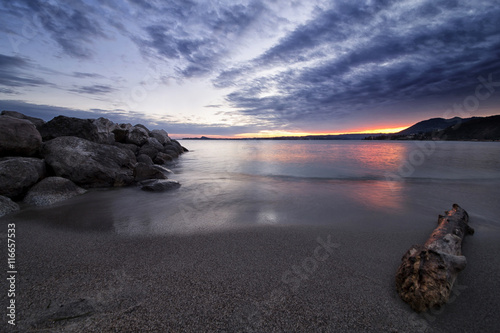 Sunset on Garda Lake, Italy, panoramic view from the sand beach under a cloudy s Poster