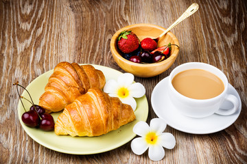 Wall Mural - Cup of coffee and croissants on wooden background