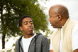 © digitalskillet1 - African American father and son in deep conversation.