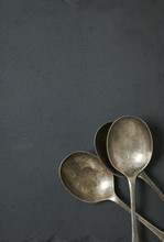 Antique Style Serving Spoons On A Rustic Slate Background Forming A Page Border