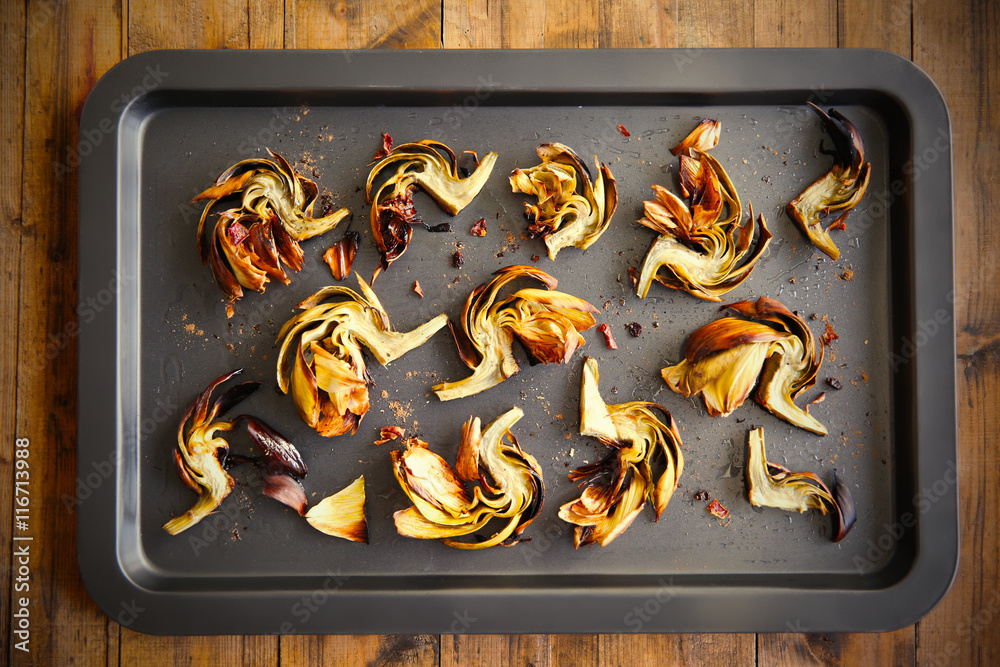 Baked artichokes with spices on a baking tray