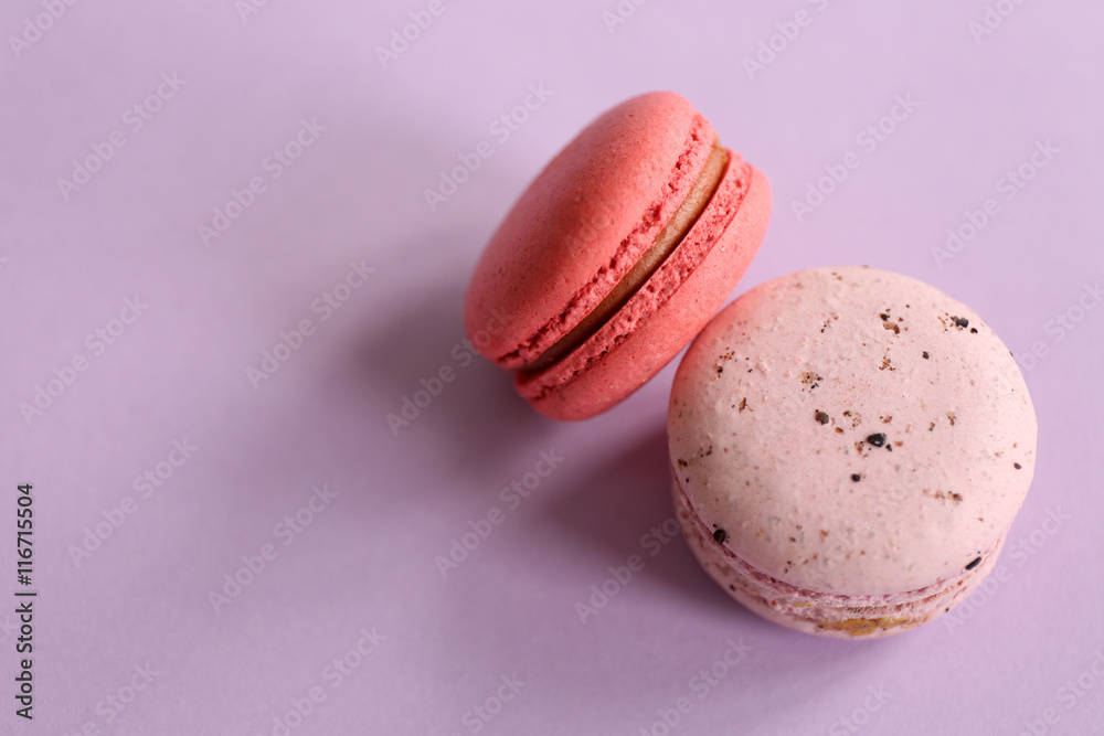 Colorful tasty macaroons on purple background
