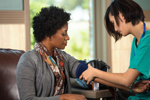 Nurse Checking A Patients Blood Pressure.