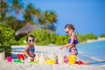 Wall Mural - Little girls playing with beach toys during tropical vacation