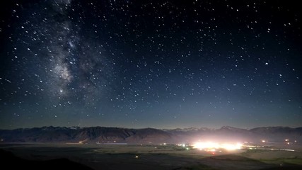 Wall Mural - Amazing time-lapse of the night sky rotating above a small town.