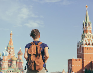 Young attractive woman traveler with backpack on the background