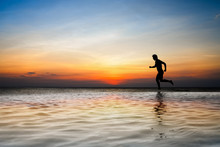 Silhouette Of Man Running On The Beach