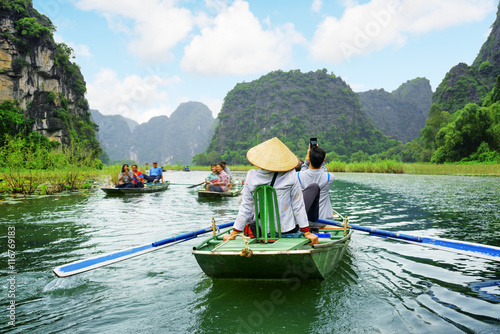 Stampe Tourists in boats. Rowers using feet to propel oars, Vietnam
