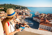 Young Female Traveler With Red Backpack And Hat Enjoying The View From George's Tower On Piran Old Town. Traveling In Slovenia