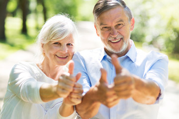 Poster - Senior couple showing thumbs up
