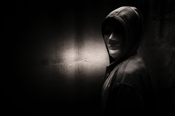 Wall Mural - A stranger woman wearing hoodie with white mask hiding in the dark,Scary background for book cover