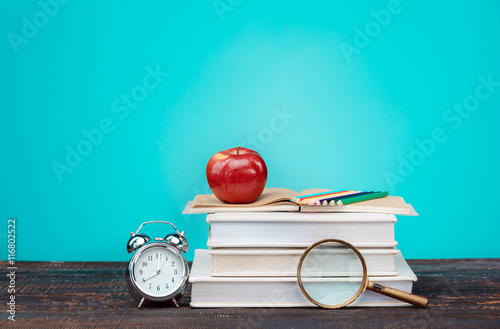Stampe Back to School concept. Books, colored pencils and clock
