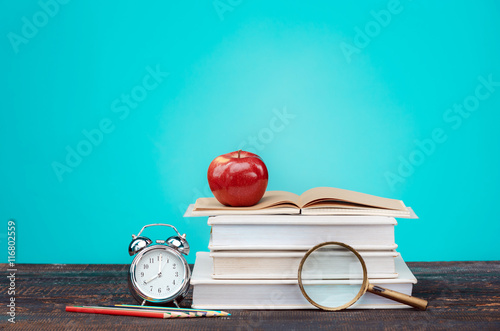Stampe Back to School concept. Books, colored pencils and clock