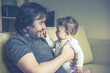 © scaliger - Happy father plays with his baby at home, vintage style photo