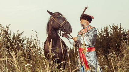 Wall Mural - King dressed in medieval costume is stroking his horse 