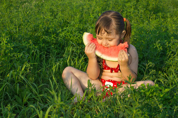 little white girl children sit on grass and hold watermelon