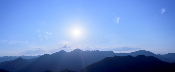 Panorama of sun flare with blue sky and mountains