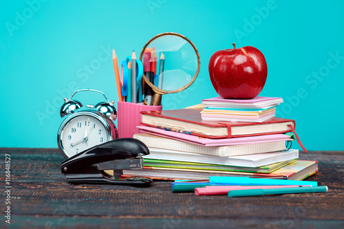 Stampe Back to School concept. Books, colored pencils and clock