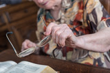 Fototapeta Desenie - Old woman holding her glasses
