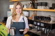 © WavebreakmediaMicro - Portrait of smiling waitress making cup of coffee