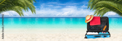 open suitcase on tropical p...