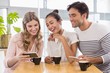 © WavebreakmediaMicro - Group of friends using mobile phone while having cup of coffee