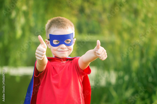Fotografering Kid in superhero costume showing thumbs up. T