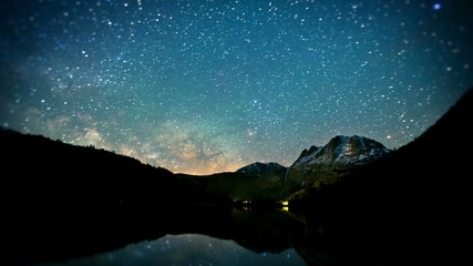 Wall Mural - Amazing time-lapse of the night sky with the stars being reflected in a lake.