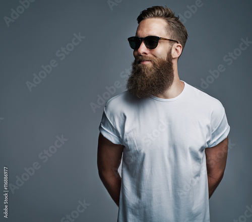 Cuadros en Lienzo Bearded handsome man with sunglasses looking over
