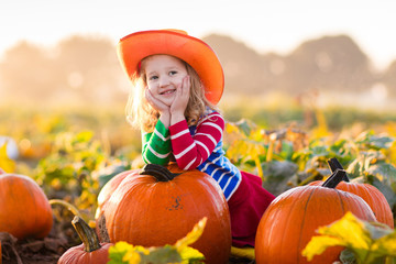 child playing on pumpkin patch