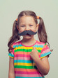 © Myst - beautiful cute little girl playing with mustache
