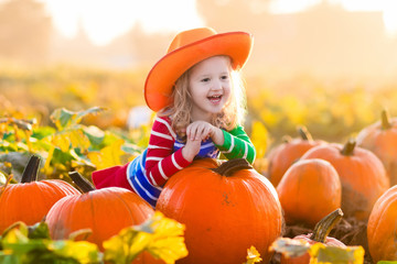 child playing on pumpkin patch