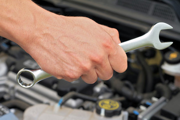 Wall Mural - Car service concept, Mechanic Hand Hold Spanner Tool, man checking the condition of car engine.