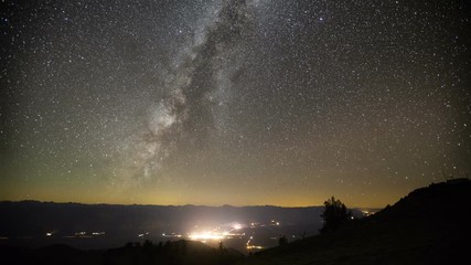 Wall Mural - Amazing time-lapse of the night sky rotating above a small town.