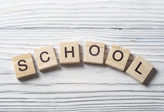 school word on wood cube at wooden background. Alphabet blocks