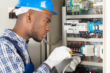 Technician Repairing Fusebox With Screwdriver