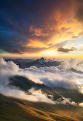 Wall Mural - high mountain ridge in the clouds during sunrise. beautiful panoramic landscape