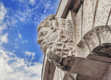Historic Building Detail Man Head With Blue Cloudy Sky