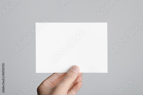 Fotografía A6 Flyer / Postcard / Invitation Mock-Up - Male hands holding a blank flyer on a gray background