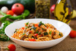 Vegetarian Vegetable pasta Fusilli with zucchini, mushrooms and capers in white bowl on wooden table