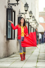 Young Woman Is Walking In A City Holding Red Umbrella And Checking Is It Raining.