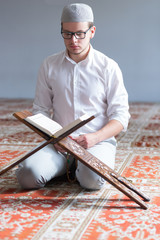 Wall Mural - Young Muslim Man Reading The Koran