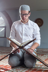 Wall Mural - Young Muslim Man Reading The Koran