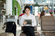 Asian young business woman at the airport, using her tablet computer