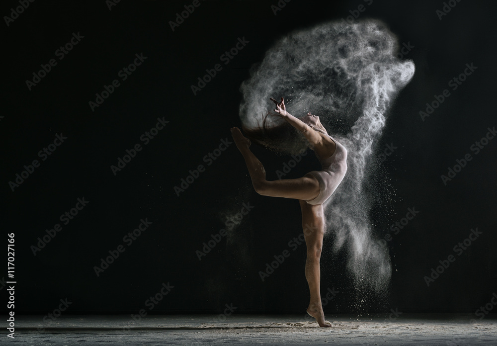 Concept. Flexible girl dancing in cloud of dust - obrazy, fototapety, plakaty 