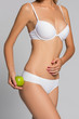© Alexander Molofeev - Beautiful woman body and green apple. Conceptual image of dieting healthy lifestyle