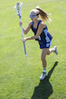 Action photo of a cute female Lacrosse player running with her lacrosse stick
